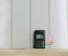A sleek payment terminal with buttons against a white wooden background, ideal for finance concept.